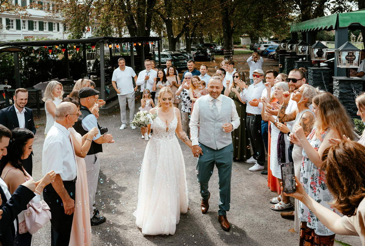 Hochzeitsfotograf und Videograf Frankfurt, Brautpaar bei der Feier, viele Gäste feiern, emotionale Hochzeitsmomente, professionelles Hochzeitsvideo und -fotografie, outdoige Hochzeit in Frankfurt, stilvolle Hochzeitsreportage.