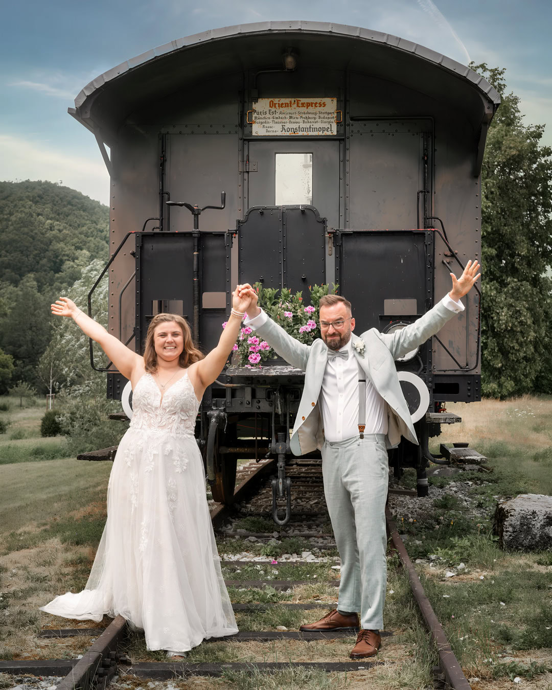 Ein glückliches Brautpaar freut sich nach der Hochzeit auf einer alten Güterbahn. Professionelle Hochzeitsfotografie in Frankfurt, die besondere Momente und Emotionen einfängt.
