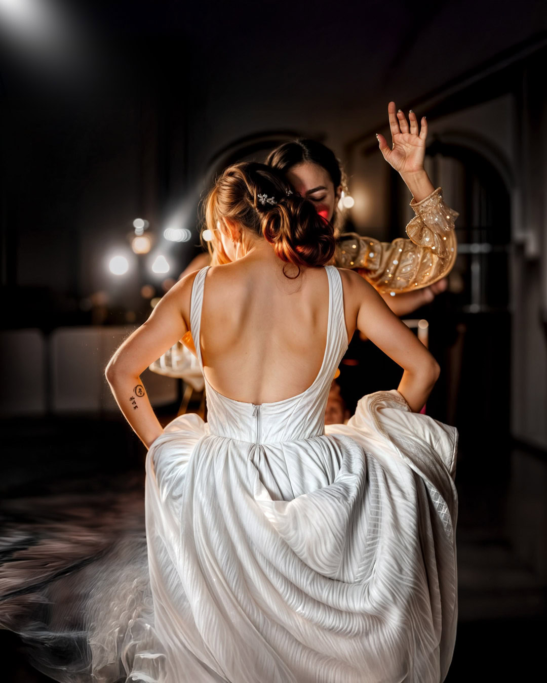 Zwei Frauen tanzen bei einer Hochzeit in Frankfurt, eine trägt ein elegantes weißes Brautkleid, die andere ein festliches Kleid, in einem stilvollen Raum mit warmem Licht.